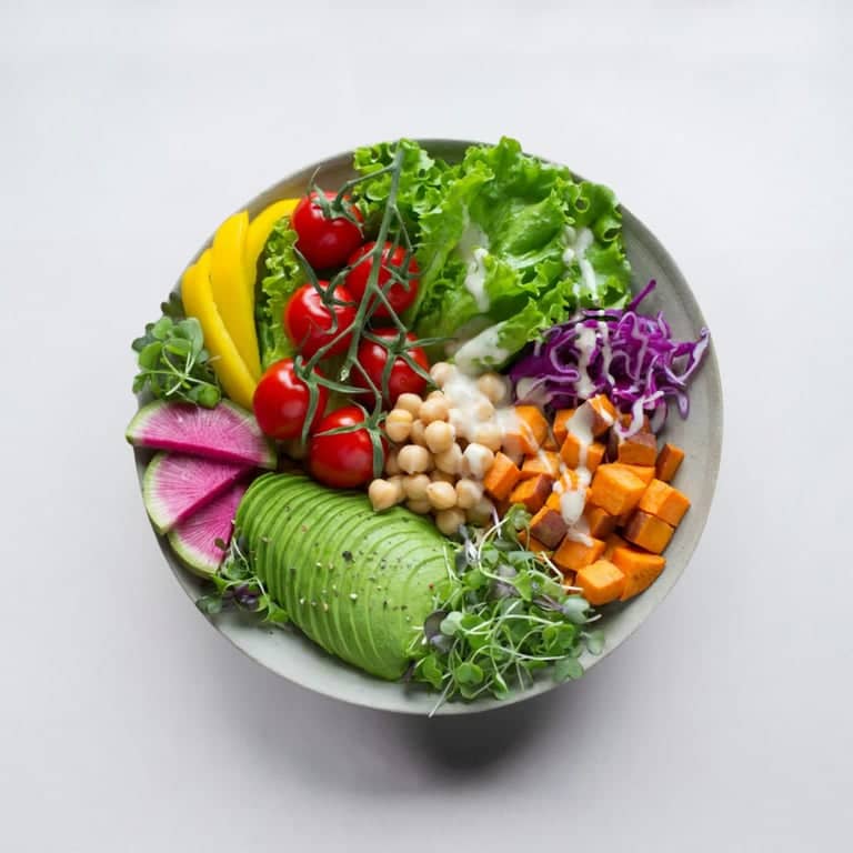 A green bowl with grains and vegetables